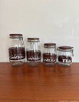 Front view of all four labeled glass canisters