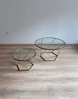Larger and smaller round glass tables side by side on wood floor