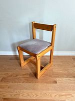 Front three-quarter view of the wood chair showing seat, backrest and frame
