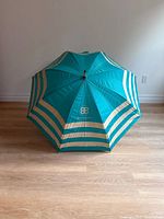 Closed umbrella showing full striped canopy and BB logo