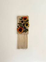 Full view of woven tapestry hanging on wall showing overall size and fringe