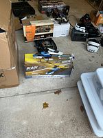 Multiple RC items on floor: Blade SR helicopter on box, Traxxas Nitro 4-Tec chassis with box, Spektrum DX6i box, white FPV goggles, charger