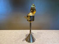 Full view of brass whale oil lamp showing pedestal, reservoir, spout, lid and backplate