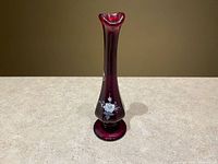 Full view of cranberry bud vase showing form, color and painted floral motif