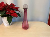 Full view of cranberry glass vase with lavender stopper assembled