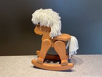 Side view of entire wooden rocking horse showing wood construction and yarn mane