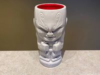 Front view of grey tiki-style Drax mug with red interior