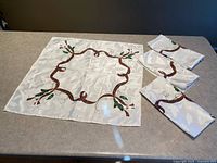 One napkin fully opened next to three folded matching napkins