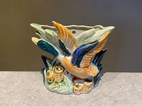 Front view of ceramic wall pocket showing flying duck and reeds