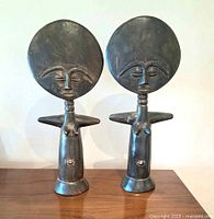 Front view of both carved wooden Akua'ba dolls standing side by side