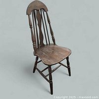 Front view of wooden brace back Windsor chair showing spindle back, splat, seat and legs