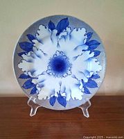 Front view of blue and white porcelain plate with peony design on stand