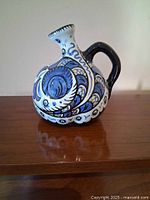 Front view of hand-painted Gouda vase showing handle and decoration