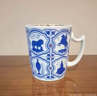 Front view of blue and white porcelain mug showing bear and rider motifs