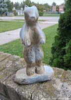 Full view of standing soapstone polar bear sculpture on outdoor surface