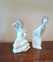 Front view of both porcelain figurines side by side on tabletop