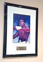 Framed signed Muhammad Ali print displayed on wall