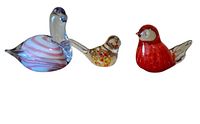 Front view of three glass bird paperweights