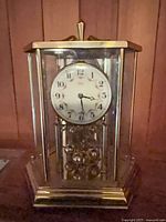 Front view of Kundo brass 400-day mantel clock showing dial and pendulum