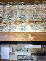 Row of tall hammered-texture goblets on shelf