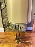 Full view of lamp with shade showing brass-tone lyre design and cord