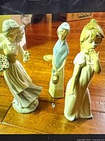 Front view of all three Nao porcelain girl figurines