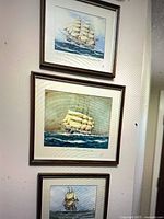 Vertical arrangement of three framed nautical prints on wall