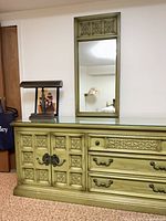 Front view of olive green dresser with mirror, showing carved doors and drawers