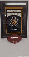 Full view of framed Raptors banner and Bears football