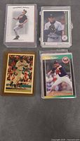Four star baseball cards in hard cases including Cal Ripken Jr., Boston player, gold bordered card and Nolan Ryan Rangers card