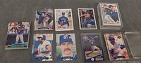 Nine Blue Jays cards laid out including Roberto Alomar, Dave Stieb, Joe Carter; some in toploaders