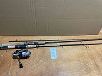 Two spinning rods laid out side by side, one with reel attached