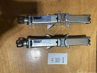 Top view of two stainless steel scissor jacks on table