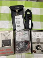 Overall lot showing three testers: boxed Micronta battery tester, Amprobe clamp ammeter with case, Amprobe multimeter