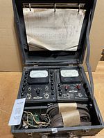 Overall view of case open showing both meters, leads and papers