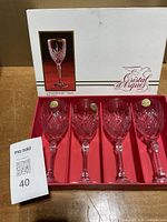 Box open displaying four crystal wine glasses in red tray