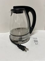 Full view of glass kettle on base, power cord visible