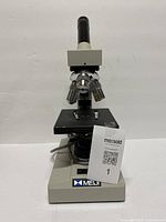 Front view of Meiji microscope showing objectives, stage, eyepiece and branding