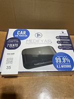 Front of sealed box showing Medify Air car air purifier and performance claims