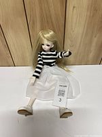 Front view of seated doll showing outfit and facial features