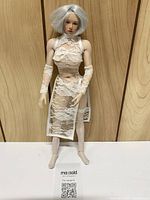 Front view of 11" Super Duck doll wearing white lace dress, arm warmers and stockings