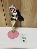 Front view of figure on pink base with QR card