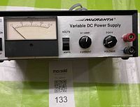 Front view showing Micronta branding, analog voltmeter, controls, binding posts