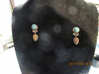 Pair of sterling silver drop earrings on display stand