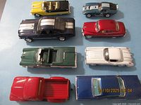 Top view of eight die-cast cars on blue background
