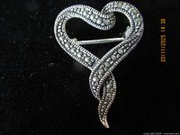 Front view of sterling silver heart brooch showing marcasite stones and design