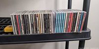Full row of approximately 45 CDs on shelf