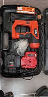Open carry case showing nailer, nails, charger, battery and accessories