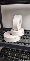 Three stacked rolls of drywall tape on shelving