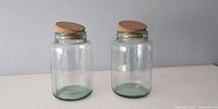 Both glass jars standing with corks in place